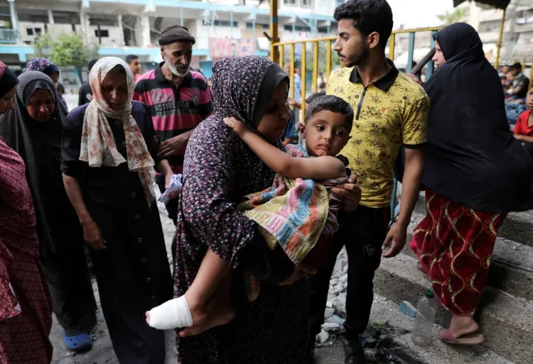 Civilians Given Proof Of Non-existent Haven In Gaza 1 A Palestinian woman carries a child at the site of an Israeli attack on a UN school sheltering displaced people in Nuseirat refugee camp in the central Gaza Strip, June 6, 2024.