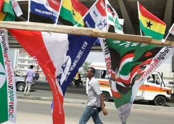 A man walk past election campaign flags on the street in Accra Ghana Dec. 6