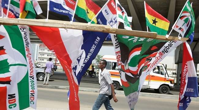 A man walk past election campaign flags on the street in Accra Ghana Dec. 6