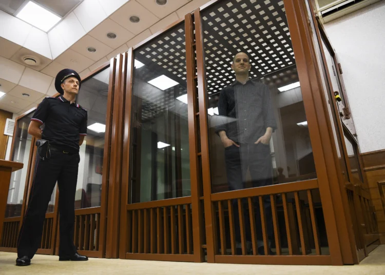 Wall Street journal reporter, Evan Gershkovich stands in a glass cage in a court room in Yekaterinburg, Russia.