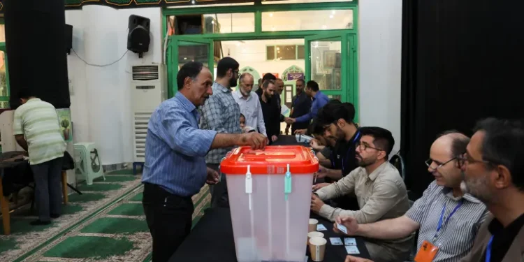 Runoff Election Underway In Iran 1 A man votes in the run-off presidential election between Masoud Pezeshkian and Saeed Jalili in Tehran.