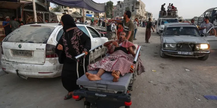 A man is transported on a hospital bed as displaced Palestinians leave an area in eastern Khan Younis after the Israeli army issued a new evacuation order for parts of the city and Rafah on July 1, 2024.