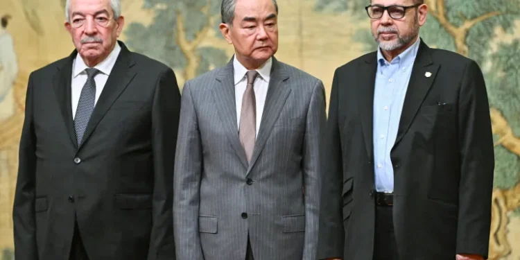 Mahmoud al-Aloul, Vice Chairman of the Central Committee of Fatah (L), China's Foreign Minister Wang Yi (C), and Mousa Abu Marzouk, senior Hamas member, attend an event at the Diaoyutai State Guesthouse in Beijing, July 23, 2024.