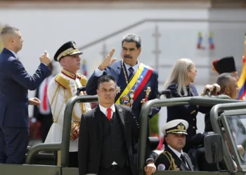 President Nicolas Maduro waving while ride at the back of a military vehicle