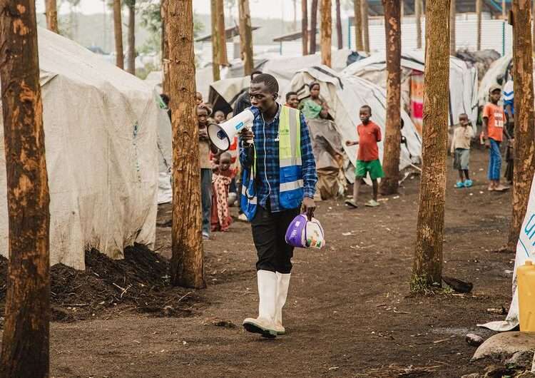 UN Warns Of Escalating Violence And Displacement In Eastern DRC 1 A community health worker walks through an IDP camp in North Kivu in eastern Democratic Republic of the Congo.