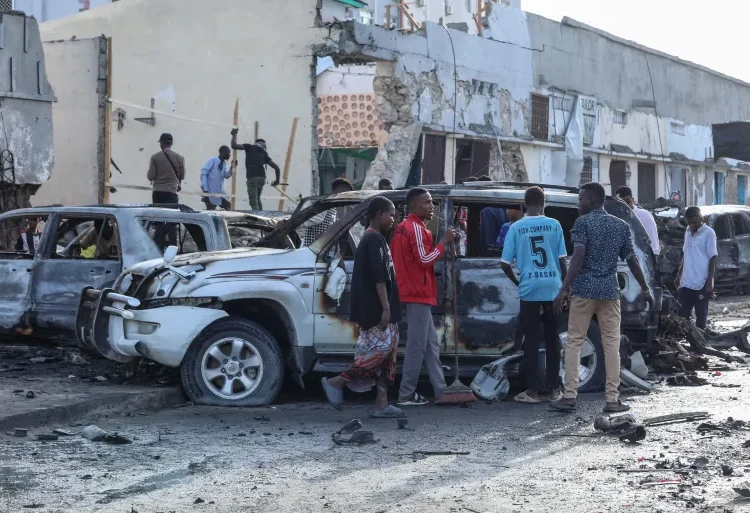 Somalia Car Bomb Attack Leaves Nine Dead, Al-Shabab Claims Responsibility 1 A group of people look at the debris and destruction at a cafe in Mogadishu following a car bomb blast