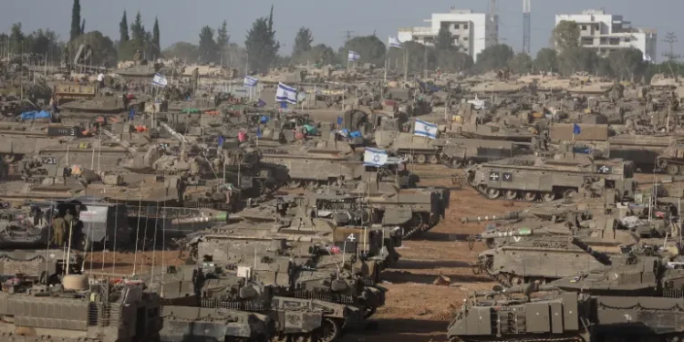 Israeli military vehicles gather near the border fence with the Gaza Strip, in southern Israel on May 9, 2024.