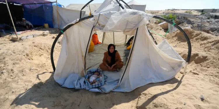 A displaced Palestinian woman and a child shelter in a cemetery in Khan Younis.