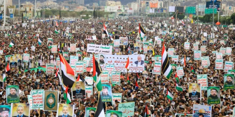 Yemenis wave flags and lift placards of Hezbollah senior commander Fuad Shukr, who was killed in an Israeli strike, and slain Hamas chief Ismail Haniyeh, during a rally in the Houthi-controlled capital Sanaa.
