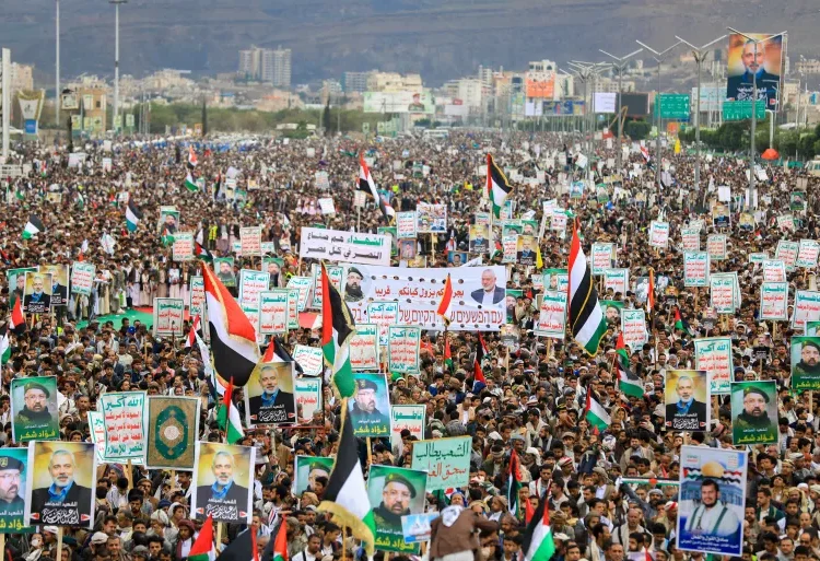 Yemenis wave flags and lift placards of Hezbollah senior commander Fuad Shukr, who was killed in an Israeli strike, and slain Hamas chief Ismail Haniyeh, during a rally in the Houthi-controlled capital Sanaa.