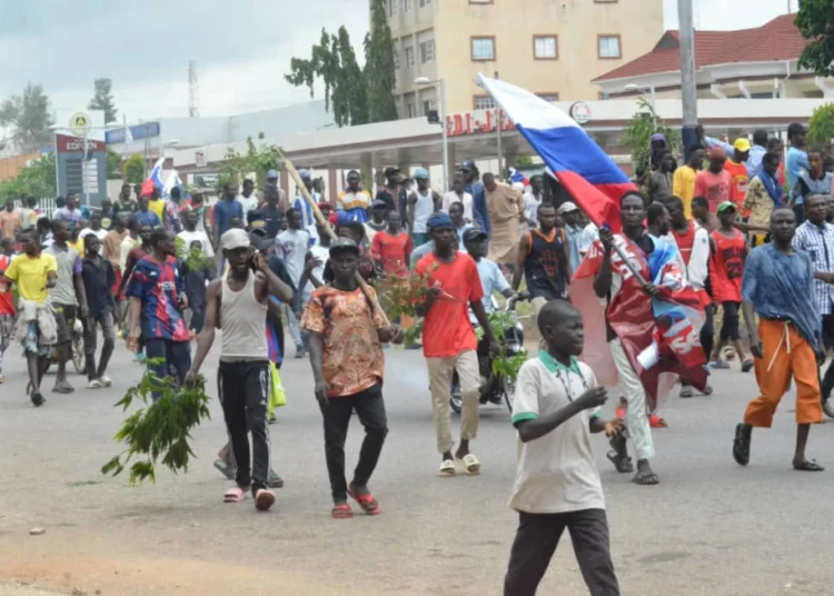 People wave Russian flags during a protest in Kaduna, Nigeria, Monday, Aug 5, 2024.