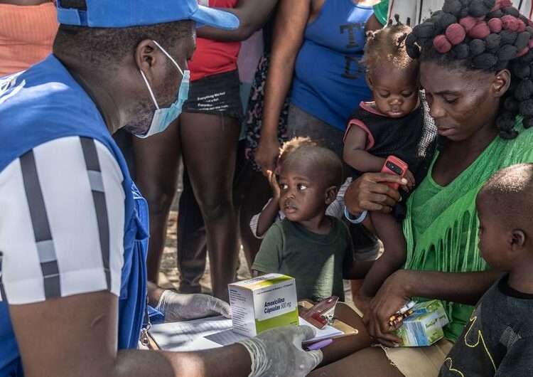 Haiti Faces Escalating Crisis Amid Humanitarian Funding Shortfall 1 A UN staff member provides medical care to a displaced woman and children.