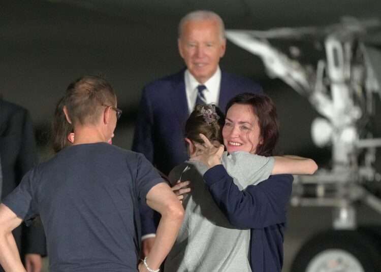A Poignant Scene Played By Allies 1 President Joe Biden looks on as Alsu Kurmasheva hugs a family member on the tarmac after arriving at Joint Base Andrews.