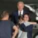 President Joe Biden looks on as Alsu Kurmasheva hugs a family member on the tarmac after arriving at Joint Base Andrews.