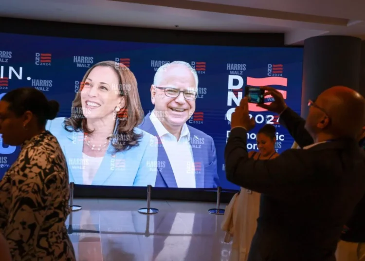Democratic National Convention Starts Tonight 1 People stand in front of a sign featuring Democratic presidential candidate, Vice President Kamala Harris and Democratic Vice presidential candidate, Minnesota Gov. Tim Walz before the start of the Democratic National Convention in Chicago.