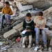 Palestinian Students Faced With Grim Prospects 13 Children write in notebooks sitting on a destroyed building near a tent being used as a makeshift educational centre for primary school students in Jabalia in northern Gaza.