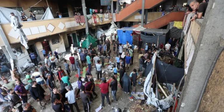 Palestinians inspect the site of an Israeli strike on a school sheltering displaced people in Deir Al-Balah.