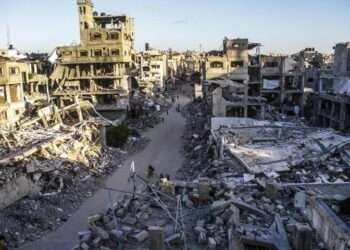 Palestinians are seen on a street between buildings destroyed in Israeli strikes in the northern Gaza Strip city of Jabalia, on Oct. 6, 2024.