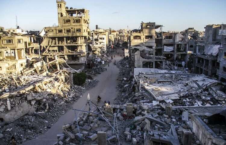 Humanitarian Tragedy Decried On War Anniversary 1 Palestinians are seen on a street between buildings destroyed in Israeli strikes in the northern Gaza Strip city of Jabalia, on Oct. 6, 2024.