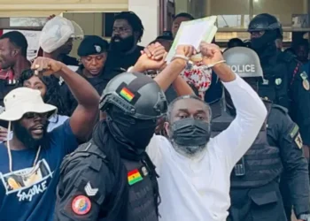 Detention of Anti-Galamsey Protestor Sparks Outrage, NCAIM Demands Release 8 Osagyefo Mawuse Oliver Barker-Vormawor in a handcuff and being escorted by the Police