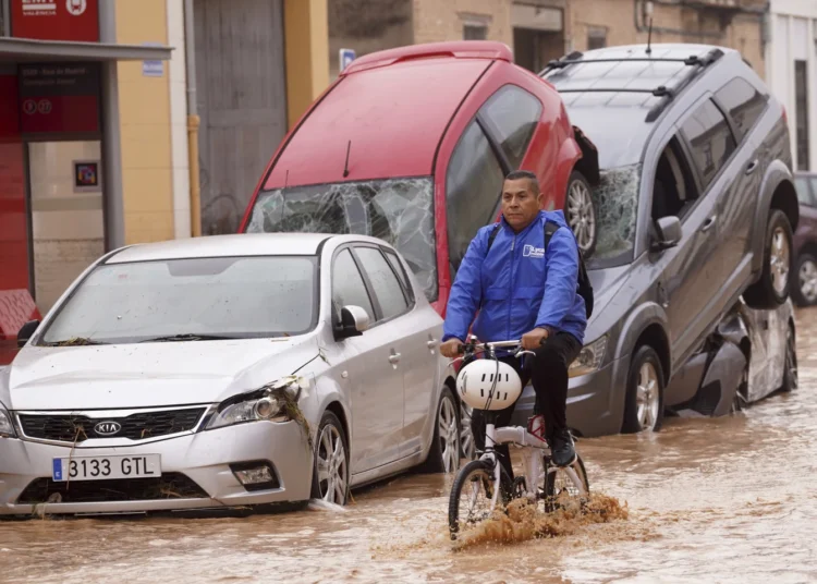 Flash Floods Claim More Than 50 Lives In Spain 1 A man rides a bicycle through flooded streets in Valencia, Spain.