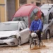 A man rides a bicycle through flooded streets in Valencia, Spain.