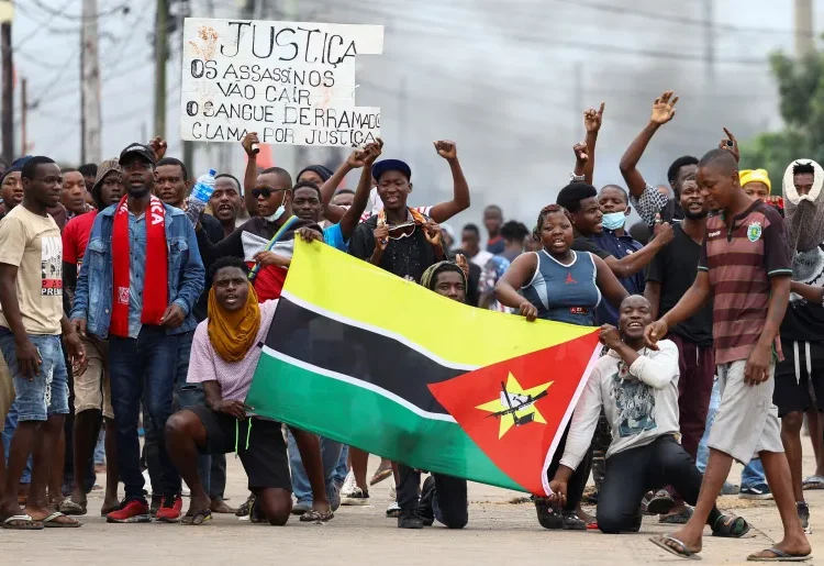 Mozambicans hold up their national flag during a nationwide strike to protest the provisional election results