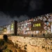 People walk by the walls of Jerusalem’s Old City as pictures of people taken captive during the October 7 attack on Israel are projected on them.