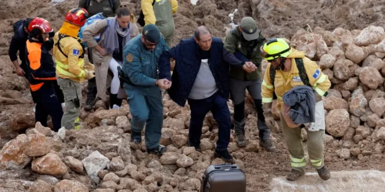 Emergency services staff help a man after deadly floods in Letur in southeastern Spain on October 30, 2024.