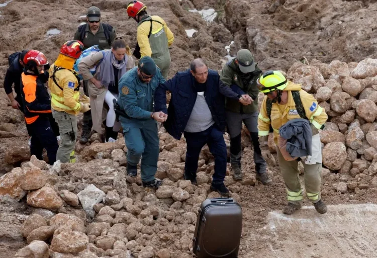 Spain Floods Death Toll Rises To 205 1 Emergency services staff help a man after deadly floods in Letur in southeastern Spain on October 30, 2024.