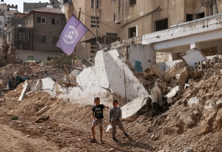 Palestinian boys stand near the damaged UNRWA headquarters at the Nur Shams refugee camp.