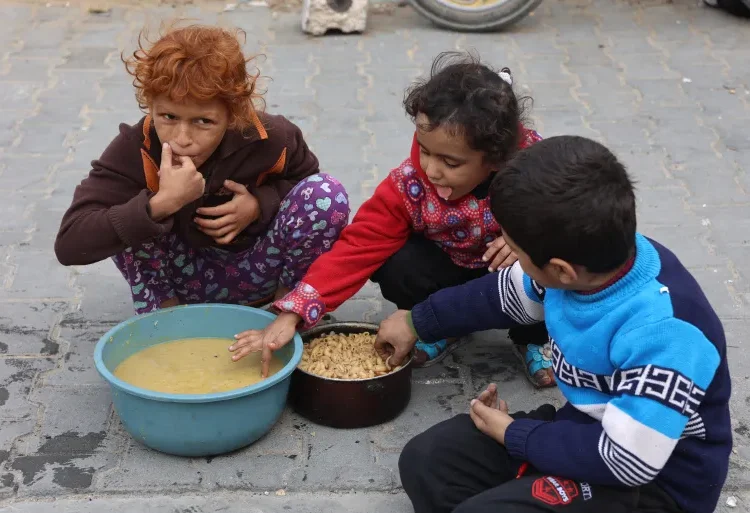 UNICEF Highlights Dire Situation For Gaza Children 1 Palestinian children taste food from a distribution centre.