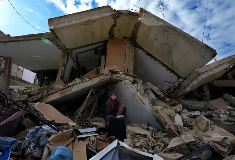 Lebanese civilian Mariam Kourani sits on the rubble of her destroyed house after returning with her family to Hanaway village in southern Lebanon on November 28, 2024.