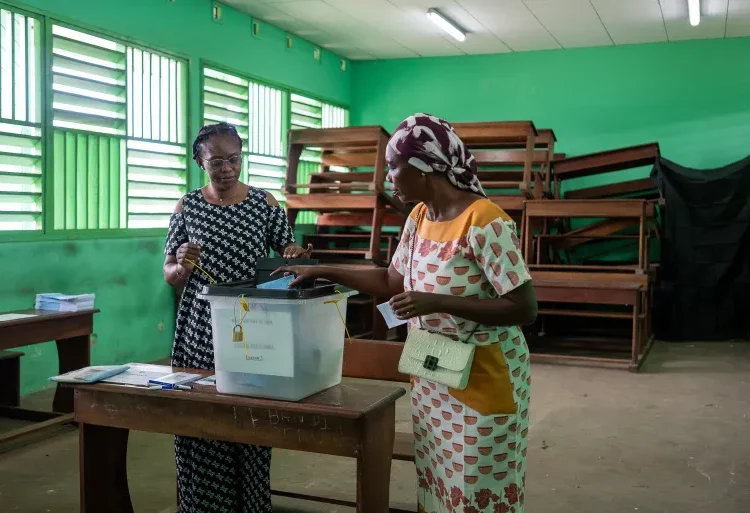 Gabon Holds Referendum to End Dynastic Rule 1 A voter casts her ballot at a polling station in Libreville, Gabon, on November 16, 2024