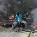 A resident carries tyres to be added to a burning barricade to deter gang members from entering his neighbourhood, in Port-au-Prince, Haiti, Tuesday, November 19