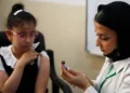 A schoolgirl receives a measles vaccine at a school in Baghdad, Iraq