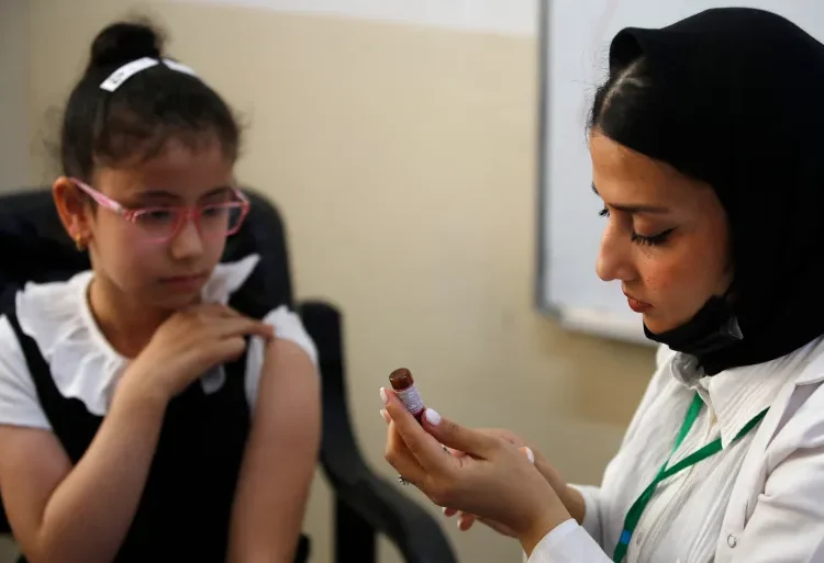 A schoolgirl receives a measles vaccine at a school in Baghdad, Iraq