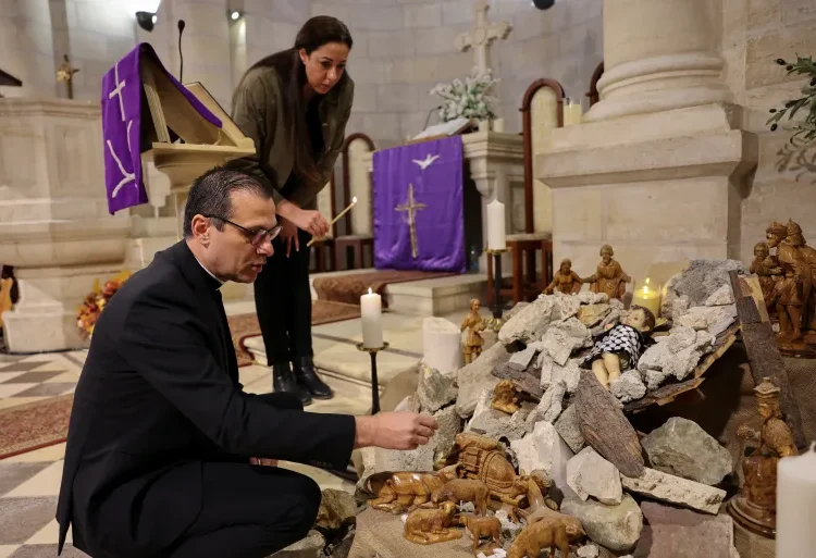 Another Gloomy Christmas Befalls West Bank And Gaza 1 Pastor Munther Isaac adds dirt to an installation that shows a figure symbolizing baby Jesus lying amidst the rubble in a grotto ahead of Christmas at the Evangelical Lutheran Church, in the Israeli-occupied West Bank.