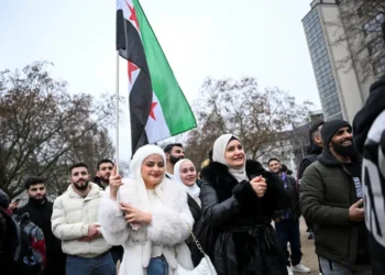 A woman carries a Syrian opposition flag during a gathering in Berlin.