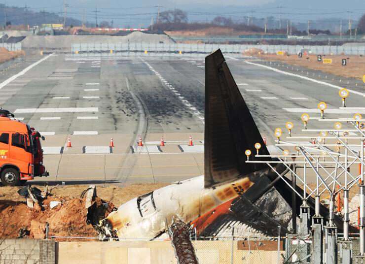 The remnants and debris of the Jeju Air passenger plane, which exploded after attempting a belly landing and colliding the previous day, remain on the runway at Muan International Airport in South Jeolla Province.