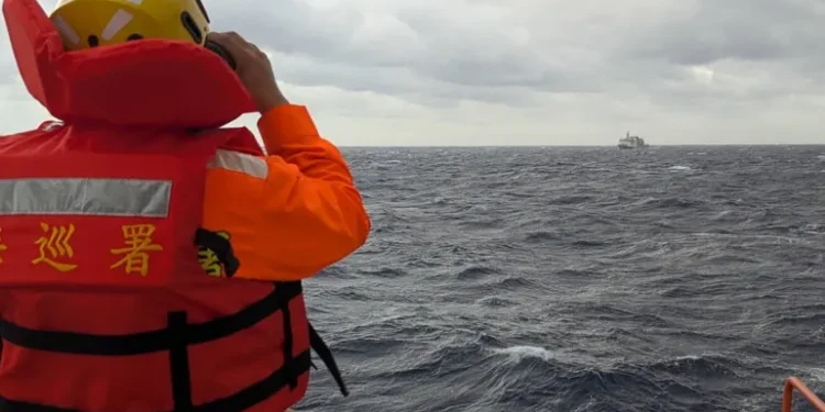 A crewmember on board a Taiwan Coastguard ship monitors a Chinese Coastguard vessel in waters east of Taiwan.