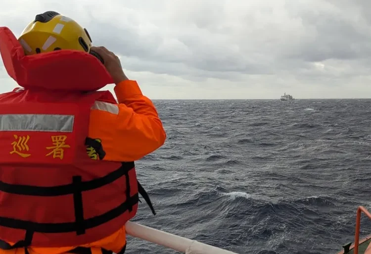 A crewmember on board a Taiwan Coastguard ship monitors a Chinese Coastguard vessel in waters east of Taiwan.