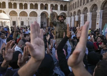 Syrians fighters and civilians chant slogans as they gather for Friday prayers at the Umayyad mosque in Damascus, Syria, Friday, Dec. 13, 2024.