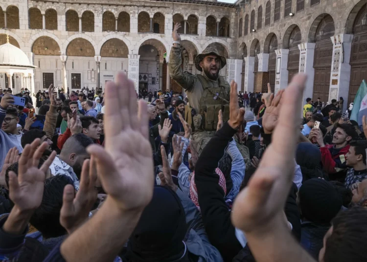 Syrians Celebrate On First Friday Prayers Post Al-Assad Fall 1 Syrians fighters and civilians chant slogans as they gather for Friday prayers at the Umayyad mosque in Damascus, Syria, Friday, Dec. 13, 2024.