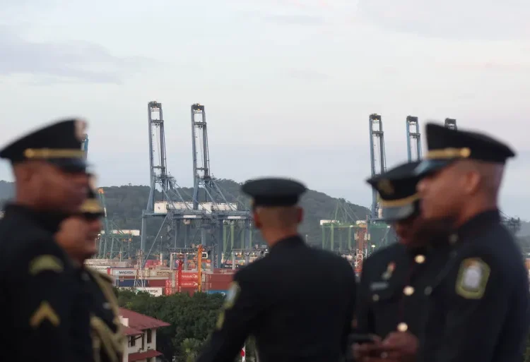 Security officers stand in front of cranes on the Panama Canal.