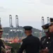 Security officers stand in front of cranes on the Panama Canal.