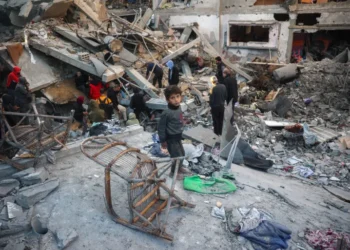 A child looks on as people search the rubble of a building destroyed in an Israeli strike on the Bureij camp for Palestinian refugees in the central Gaza Strip on January 8, 2025.