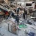 A child looks on as people search the rubble of a building destroyed in an Israeli strike on the Bureij camp for Palestinian refugees in the central Gaza Strip on January 8, 2025.