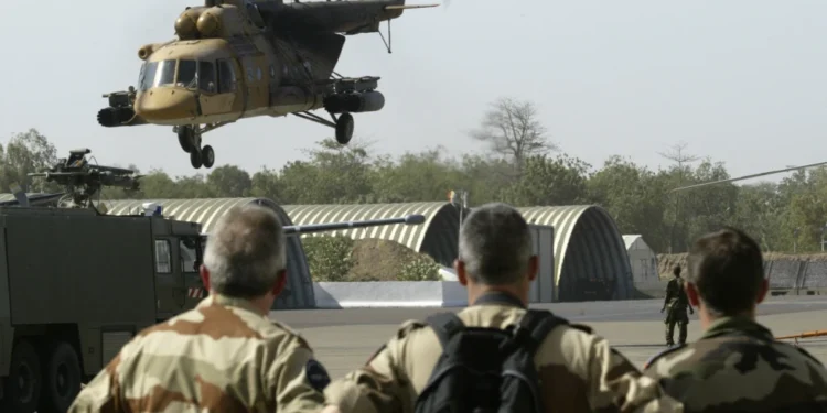 French troops watch a Chadian air force helicopter take off from N’Djamena