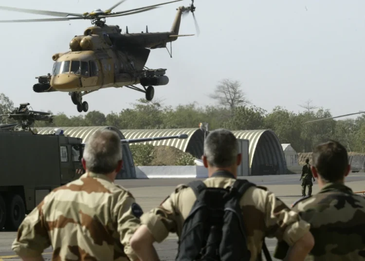 French troops watch a Chadian air force helicopter take off from N’Djamena